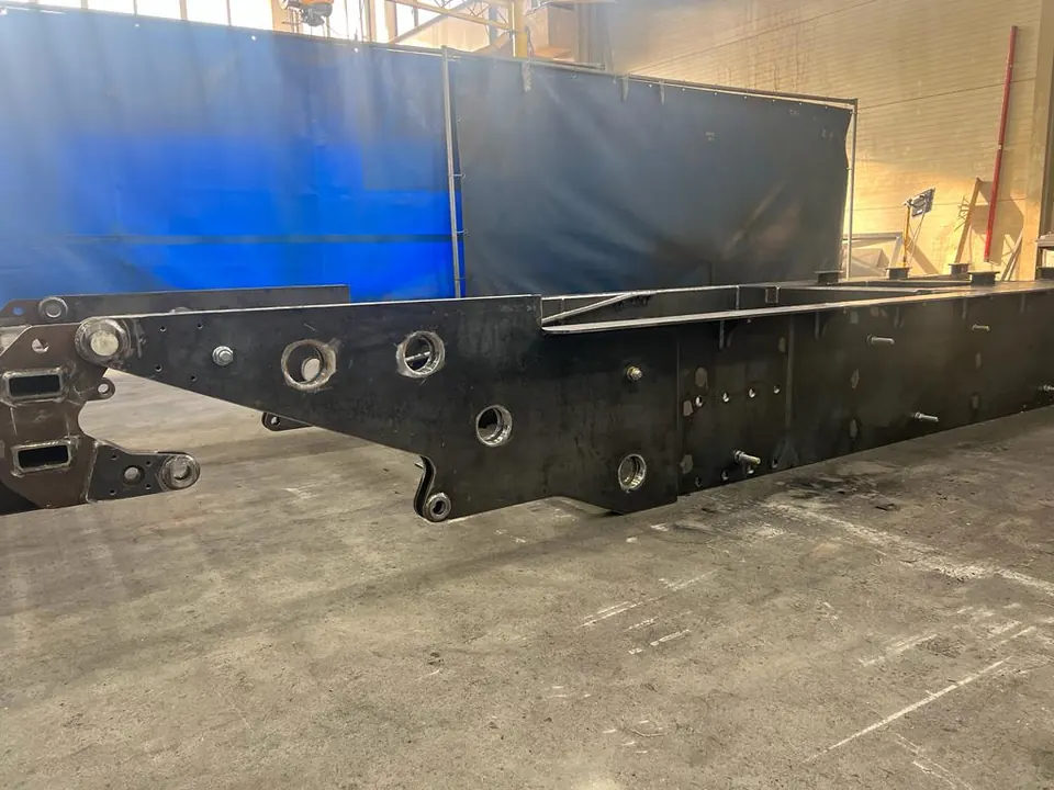 Welded machine chassis frame with bores and bushings in the hall