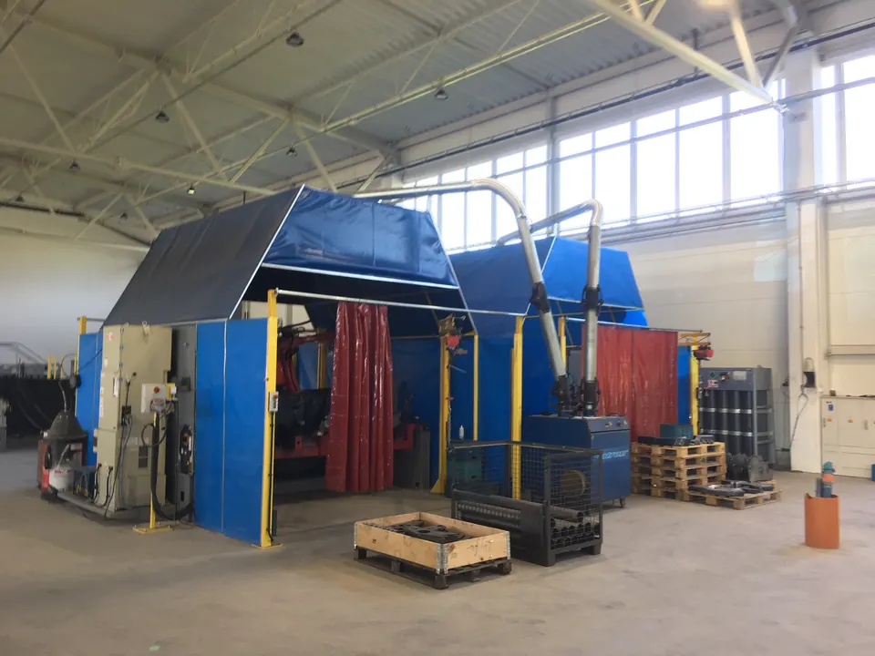 Enclosed welding stations with curtains and extraction